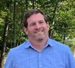 Smiling man facing camera outside 