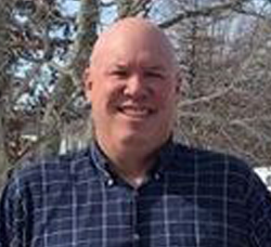 Smiling man facing camera outside 