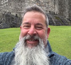 Smiling man facing camera outside 