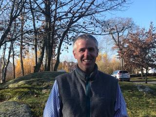 Councilor Matt Pillsbury in vest smiling standing outside